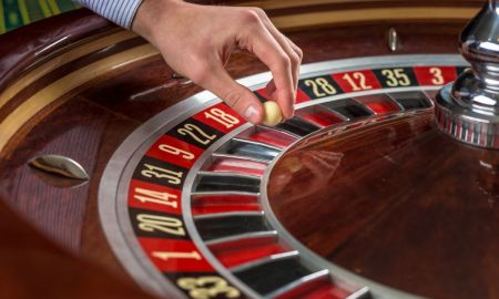 roulette wheel croupier hand with white ball casino close up details