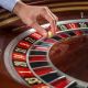 roulette wheel croupier hand with white ball casino close up details